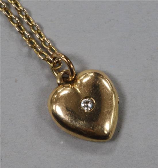 An early 20th century yellow metal and diamond set heart pendant on chain.